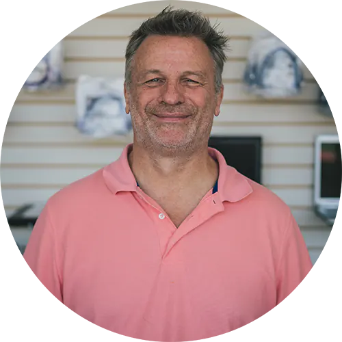 Male figure in a pink polo shirt smiling, representing VoIP Country's friendly support for MSPs in VoIP solutions.
