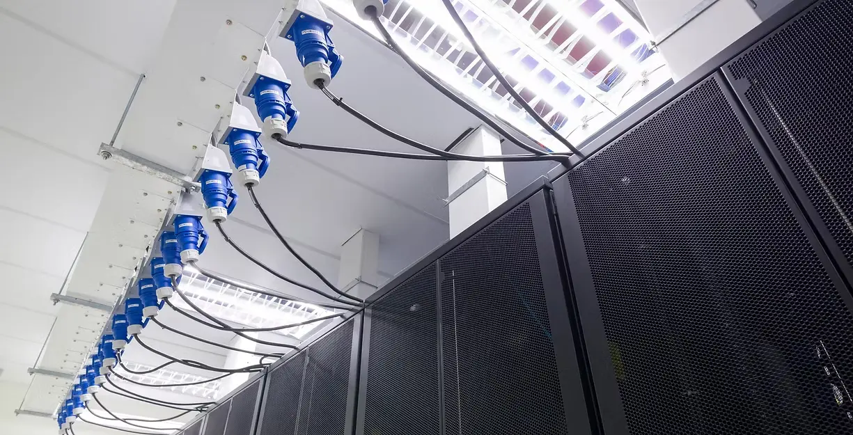 Overhead power distribution and cable runs above a data centre aisle